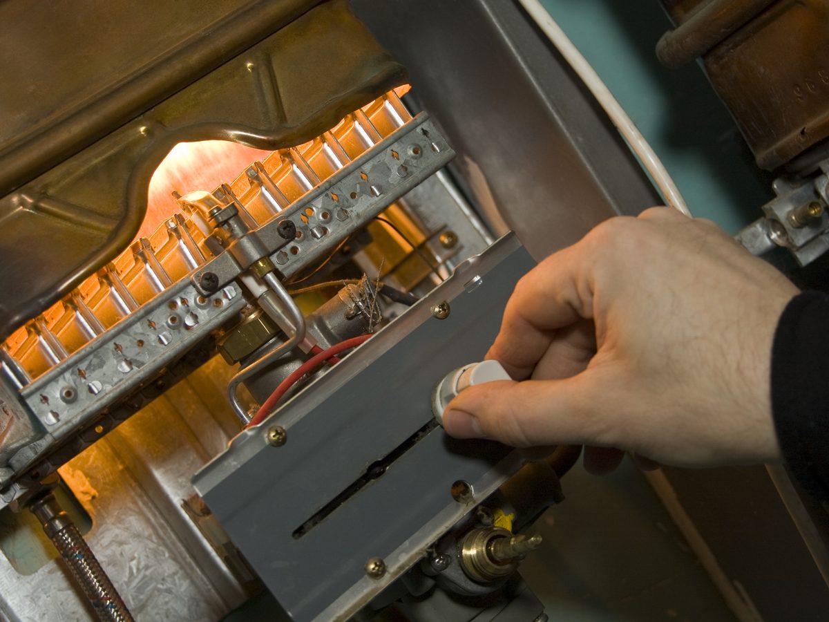 Gas boiler open for examination with its controls exposed