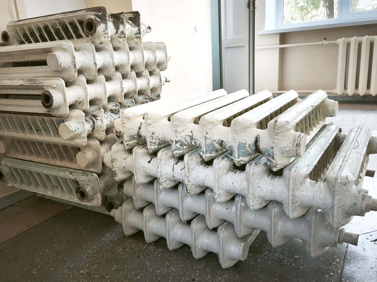 Old radiators stacked up after being taken off the wall