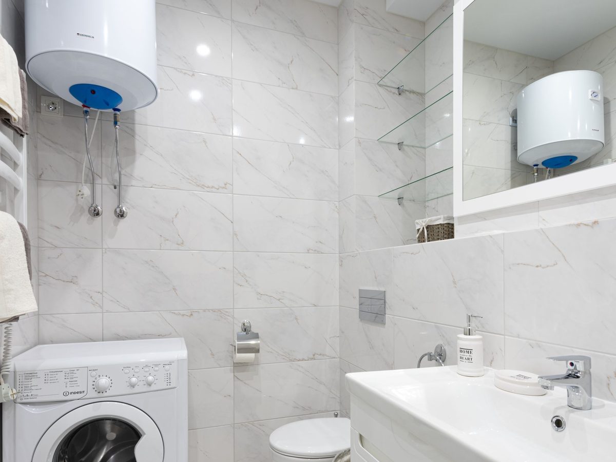 Boiler mounted in a small utility room beside a bathroom